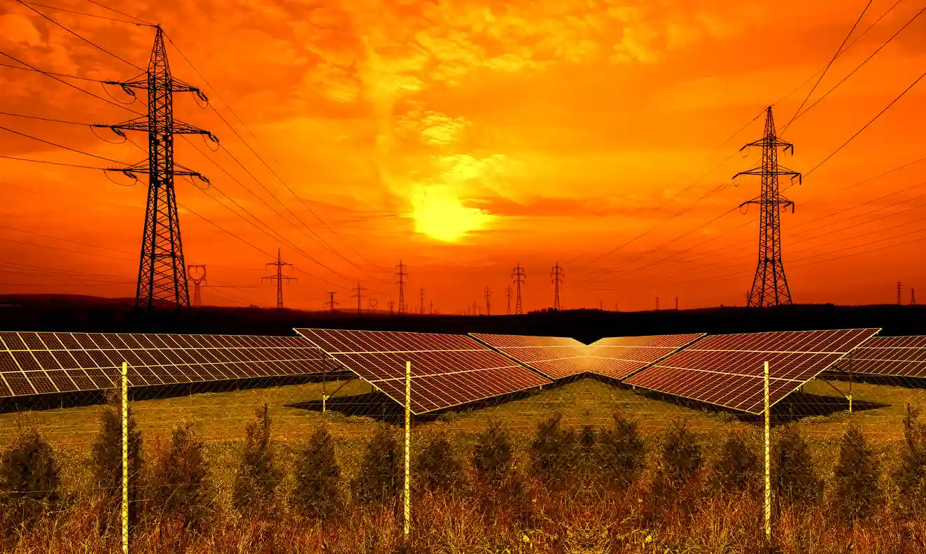 Cena de uma usina de energia solar com painéis solares em um campo ao pôr do sol, destacando a produção de energia limpa e renovável.